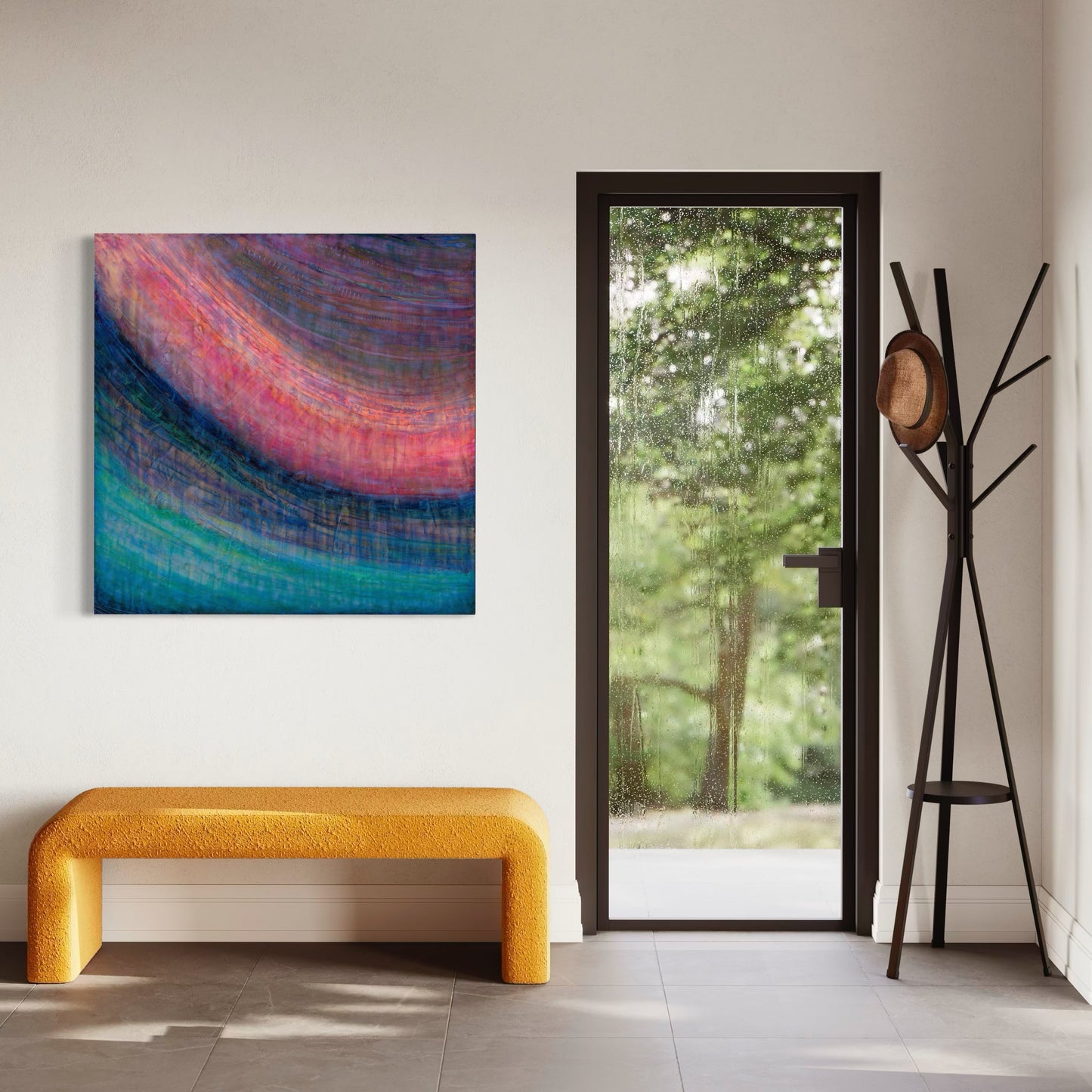 Abstract cold wax painting in a room with white walls above a modern mustard colored bench and next to a glass door with dark trim.